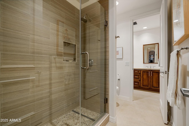 bathroom featuring tile patterned flooring, vanity, toilet, and a shower with shower door