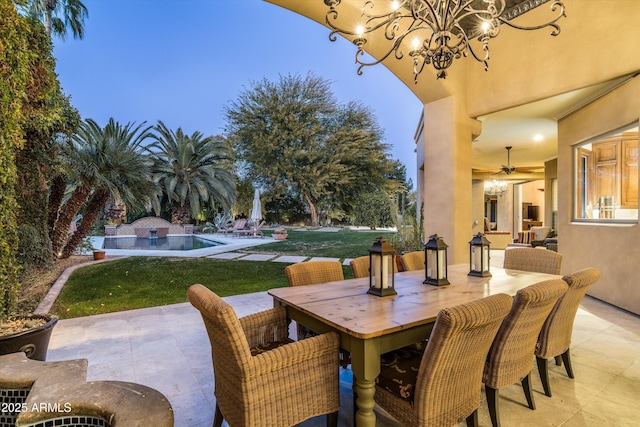 patio terrace at dusk with ceiling fan and a lawn