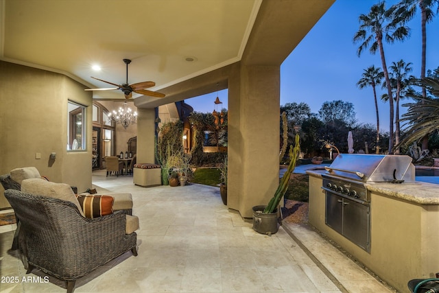 patio terrace at dusk featuring a grill, ceiling fan, and exterior kitchen