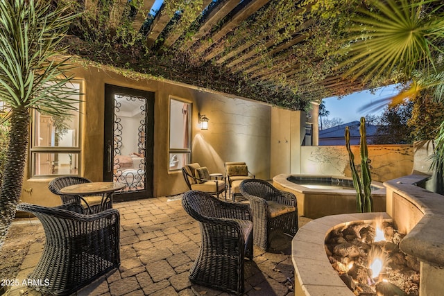 view of patio with a fire pit and an in ground hot tub