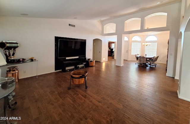 living room featuring a chandelier, dark hardwood / wood-style flooring, and high vaulted ceiling