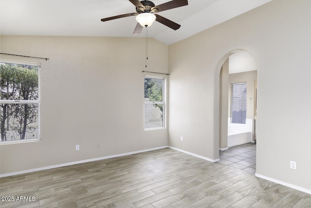 spare room featuring ceiling fan, vaulted ceiling, and light wood-type flooring