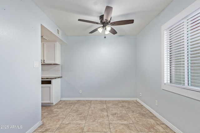 tiled empty room with ceiling fan