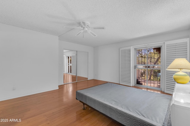 11465 N 56th St, Scottsdale, AZ 85254 - bedroom with a textured ceiling, wood finished floors, a ceiling fan, and baseboards