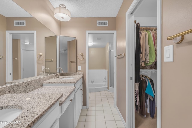 11465 N 56th St, Scottsdale, AZ 85254 - full bath featuring tile patterned flooring, double vanity, a shower stall, a spacious closet, and a textured ceiling