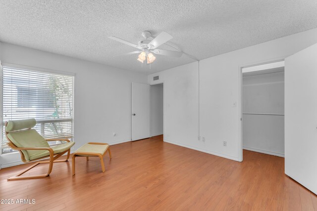 11465 N 56th St, Scottsdale, AZ 85254 - sitting room with a textured ceiling, light wood-style flooring, ceiling fan, and baseboards
