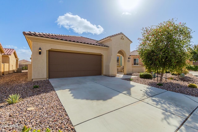 mediterranean / spanish-style house featuring a garage and central AC