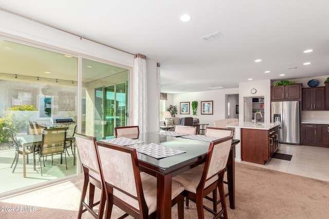 dining area featuring sink and light colored carpet