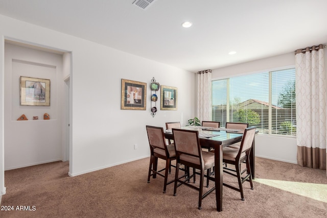 dining space featuring light carpet