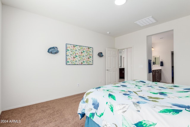 bedroom with ensuite bath and light colored carpet