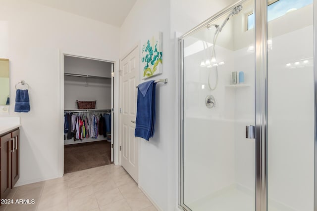 bathroom featuring an inviting chandelier, tile patterned floors, a shower with door, and vanity