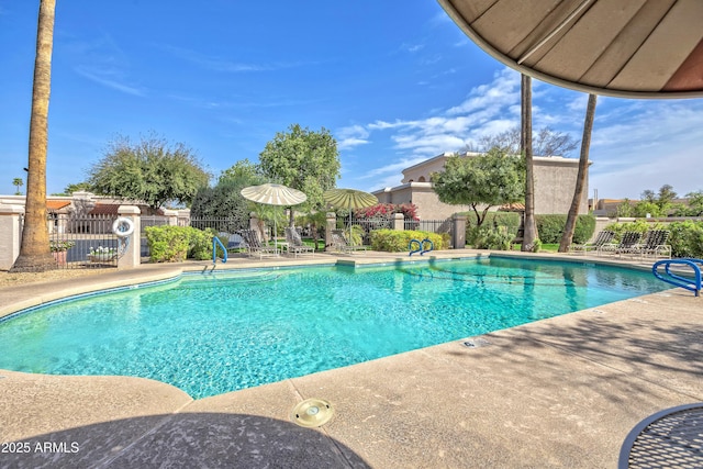 community pool with fence and a patio