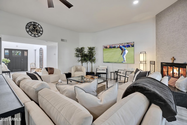 living room featuring visible vents, ceiling fan, wood finished floors, a stone fireplace, and recessed lighting