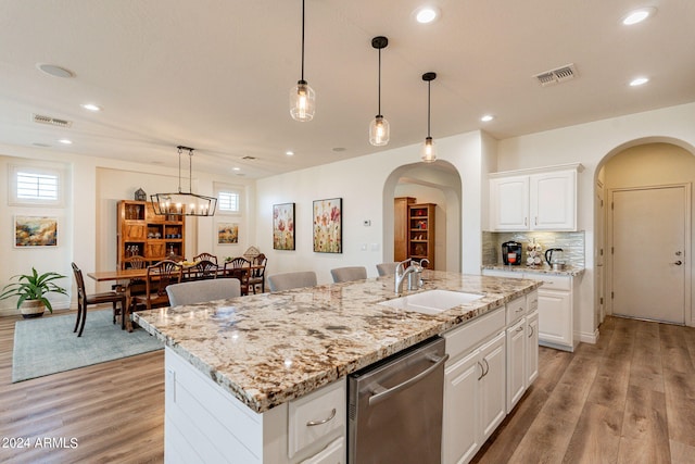 kitchen with sink, stainless steel dishwasher, white cabinets, and a center island with sink