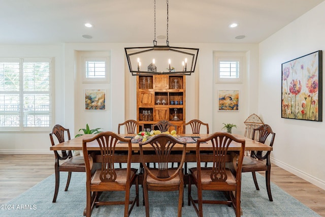 dining room featuring an inviting chandelier, a wealth of natural light, and light wood-type flooring