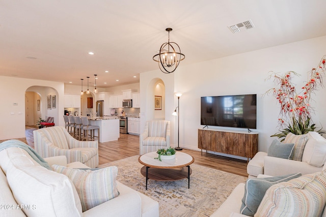 living room featuring an inviting chandelier and light hardwood / wood-style flooring