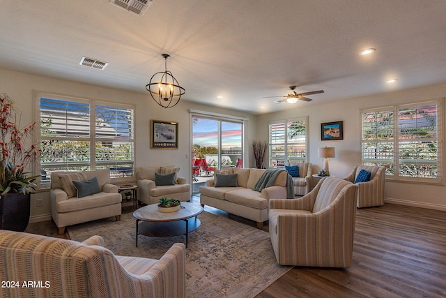 living room featuring dark hardwood / wood-style floors and ceiling fan with notable chandelier