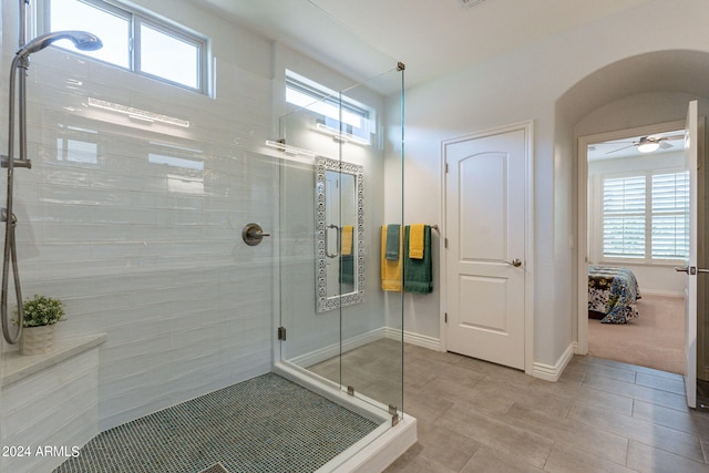 bathroom with ceiling fan, a healthy amount of sunlight, an enclosed shower, and tile patterned floors