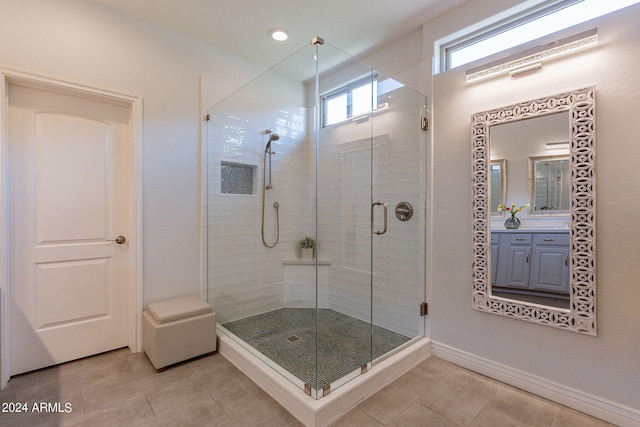 bathroom featuring tile patterned flooring, vanity, and a shower with shower door