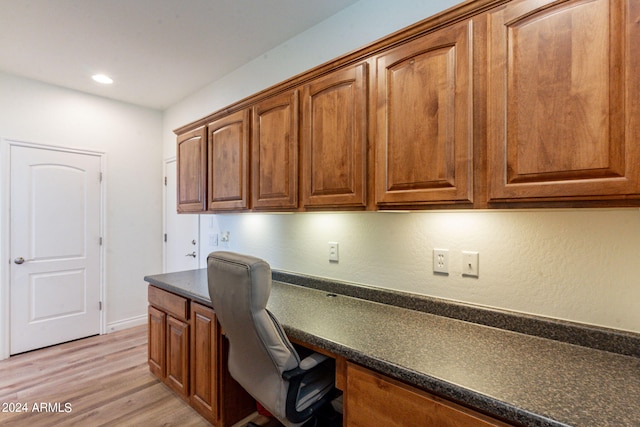 office space featuring built in desk and light hardwood / wood-style floors