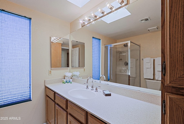 bathroom featuring vanity, a skylight, and walk in shower