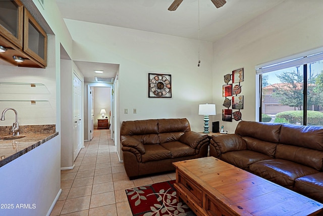 tiled living room featuring ceiling fan and sink