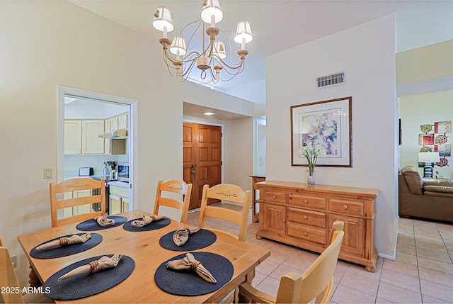 dining space featuring light tile patterned flooring and an inviting chandelier