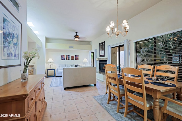 dining space with ceiling fan with notable chandelier and light tile patterned floors