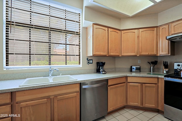 kitchen featuring light tile patterned flooring, appliances with stainless steel finishes, and sink