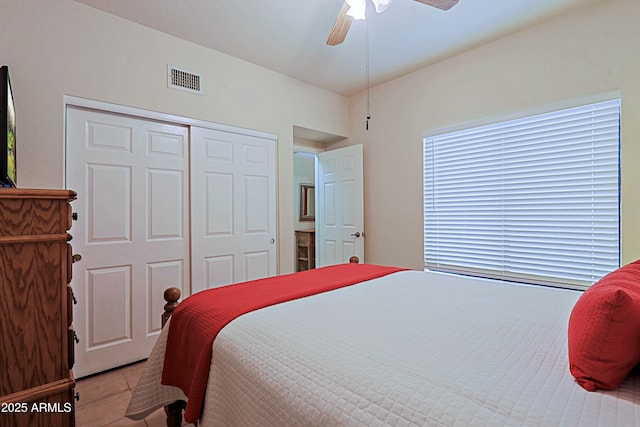 bedroom with a closet, ceiling fan, and light tile patterned flooring