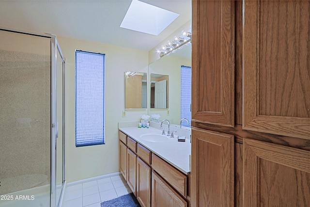 bathroom with vanity, a skylight, tile patterned floors, and walk in shower