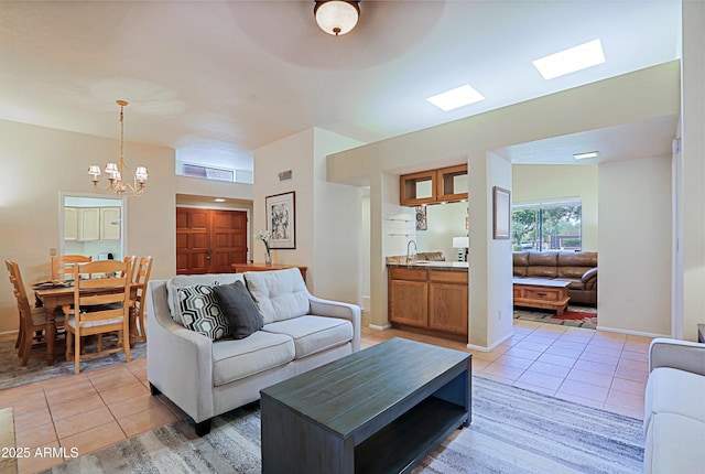 living room featuring light tile patterned flooring, sink, and a notable chandelier