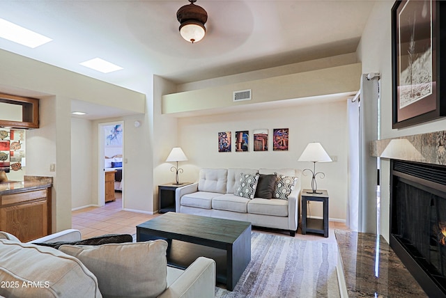 living room featuring light tile patterned floors and a high end fireplace