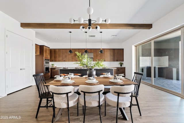 dining space featuring beamed ceiling, a chandelier, light wood-style flooring, and visible vents