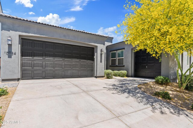view of front of house with stucco siding and driveway