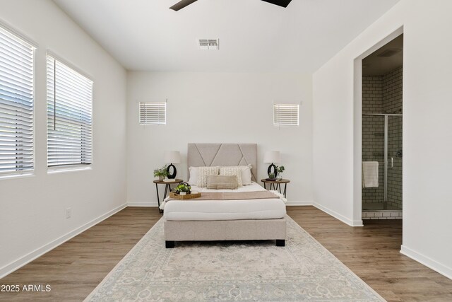 bedroom with visible vents, wood finished floors, and ensuite bathroom