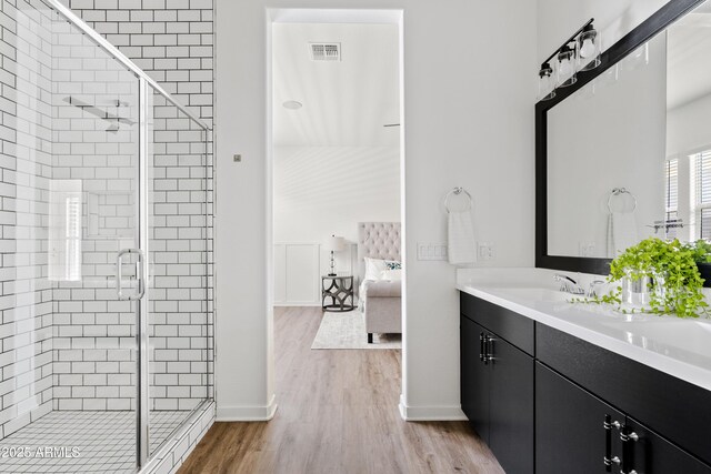 bathroom with baseboards, visible vents, wood finished floors, and a stall shower