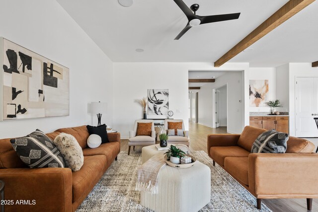 living area with baseboards, a ceiling fan, beam ceiling, and wood finished floors