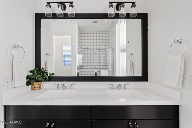 bathroom featuring double vanity, a sink, and a stall shower