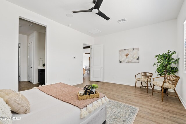 bedroom featuring baseboards, a ceiling fan, wood finished floors, and visible vents