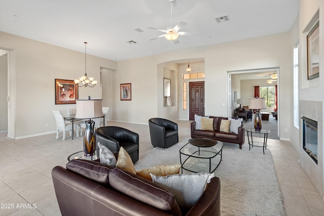 living room featuring ceiling fan with notable chandelier and light tile patterned flooring