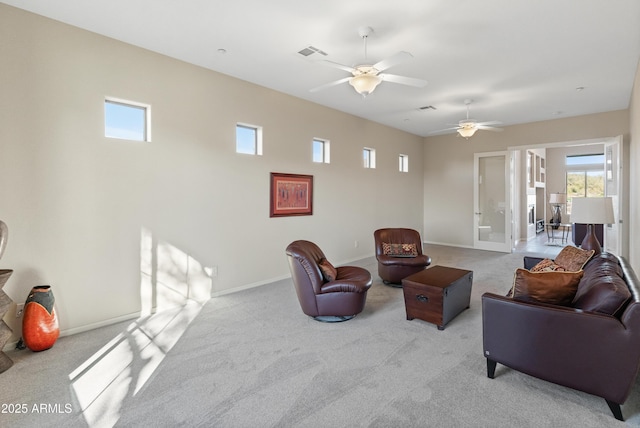 carpeted living room with ceiling fan and french doors