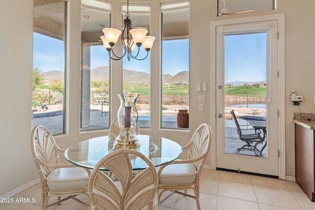 dining area featuring a mountain view, light tile patterned floors, and a chandelier