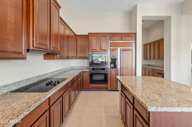 kitchen featuring built in appliances, light stone countertops, and light tile patterned floors