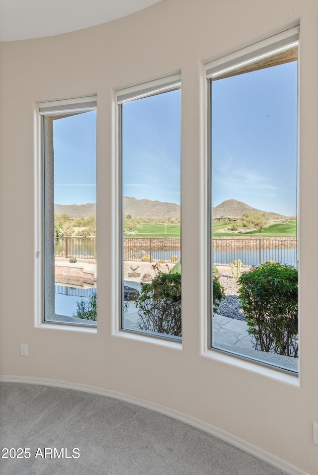 carpeted empty room with a water and mountain view