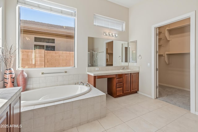 bathroom with tile patterned floors, vanity, and shower with separate bathtub