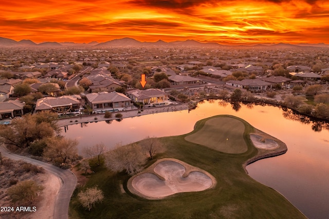 aerial view at dusk featuring a water and mountain view