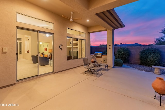 patio terrace at dusk featuring ceiling fan