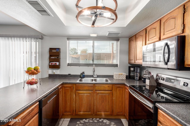 kitchen featuring visible vents, appliances with stainless steel finishes, a raised ceiling, and a sink