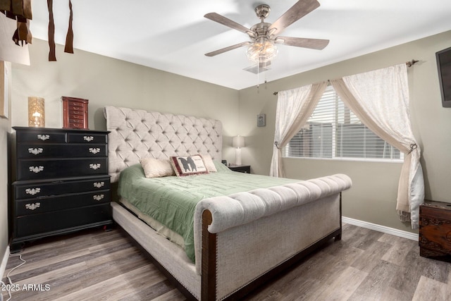 bedroom featuring visible vents, ceiling fan, baseboards, and wood finished floors